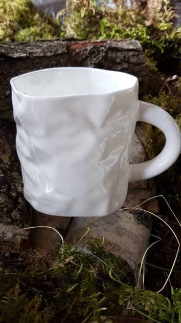 Crumpled porcelain coffee cup.